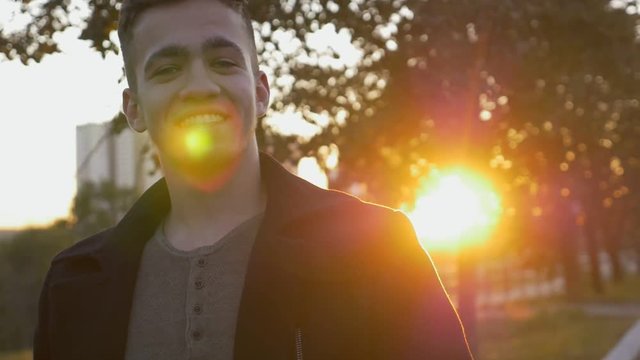 Young bearded business man in coat walk on street, smile on street with sunlight