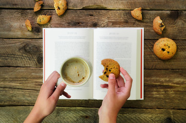 Сoffee cup, opened book, alarm clock, cookie on wooden rustic vintage background. Top view, copy...