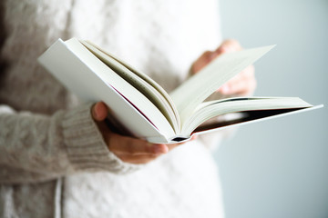 Young girl in white T-shirt reading opened book. Copy space. lifestyle and school concept