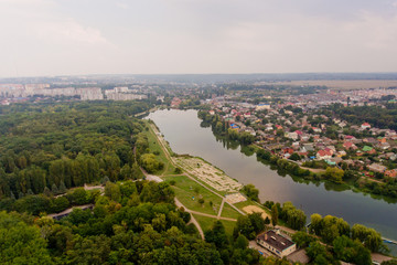 Obraz premium Arial view of a beautiful landscape of a park, a city and a lake.