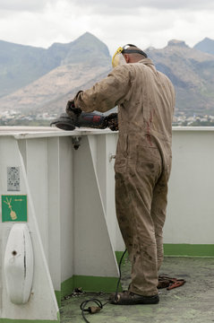 Able Seaman Working With Electrical Angle Grinder On Board The Ship.