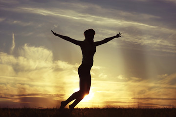 Fototapeta na wymiar Silhouette of a young girl yoga pose sunset sport