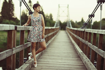 Young adult girl in a short summer dress in a rustic style