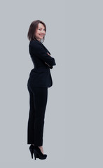 Full-length profile of businesswoman looking on camera, isolated