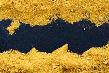 heap of curry powder on black slate background