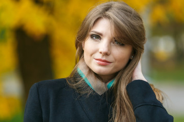 Naklejka premium Beautiful elegant woman standing in a park in autumn