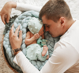 Father hugs tender his beautiful little child sleeping in the basket