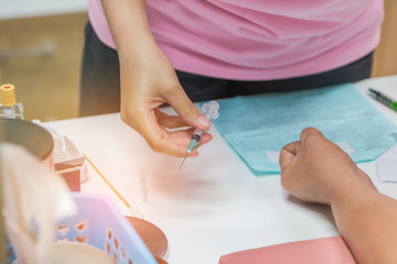 nurse holding needle syringe prepare drawing blood sample from arm patient for blood test