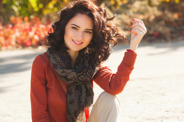 Very beautiful young woman on the autumn background. Close up portrait of smiling young pretty girl in the fall time.