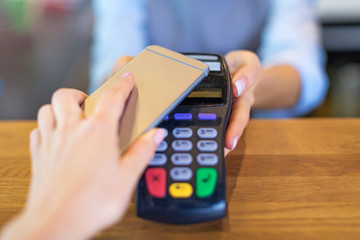 Customer Paying Through Mobile Phone In Cafe
