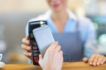 Customer Paying Through Mobile Phone In Cafe
