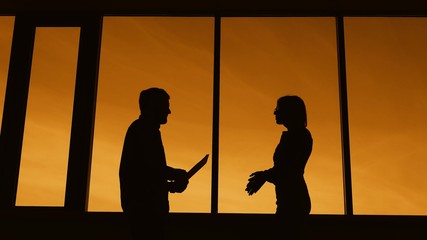 Business center. Panoramic windows. Office managers in a dark room discussing business matters.