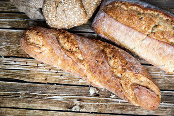 Delicious freshly baked bread on wooden background.Assortment of different types of bread on wooden background

