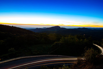 Long exposure showing the movement of traffic around curve in the street mountain at Doi Inthanon National park in the sunrise Chiang Mai Province, Thailand