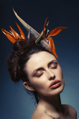 Studioportrait geschminkte Frau mit Strelitzien im Haar