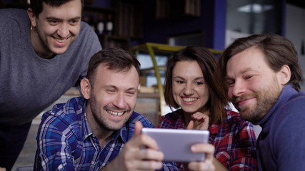 Smiling friends taking self portrait in cafe