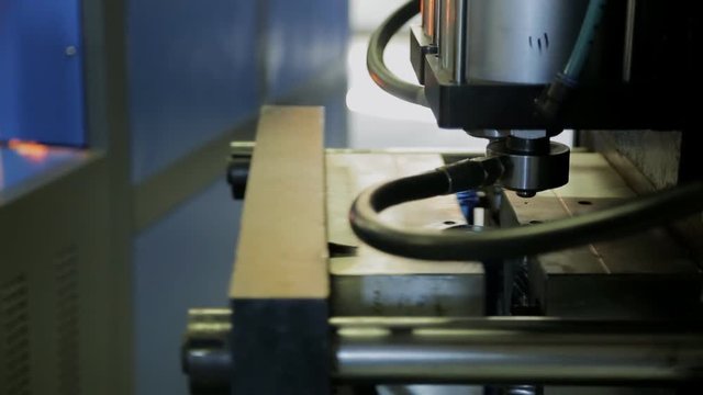 Worker at factory places preforms in machine for making plastic bottles. Female hands put two blanks in special cells, in which process of blowing transparent containers takes place.