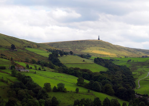 stoodley pike monument in west yorkshire landscape with upland farms and moors in the distance