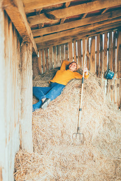 A Mature Woman Taking A Break While Working On A Farm, Laying Down In A Straw