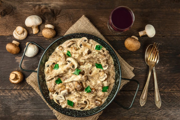 Mushroom beef stroganoff with red wine on rustic textures