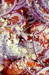 Salad with fresh tomatoes, red onion and grated feta cheese