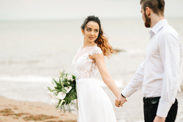 young couple groom with the bride on a sandy beach