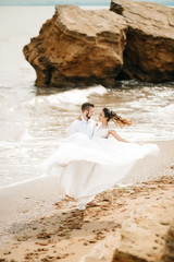 young couple groom with the bride on a sandy beach