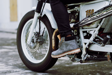 Close-up shot of male foot pressing gas pedal on vintage motorcycle, close-up shot