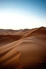 A game of shadows in the  dunes of the desert at dawn