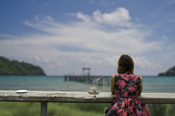 Fototapeta na wymiar Women check in. beautiful coffee shop on beach and wooden table