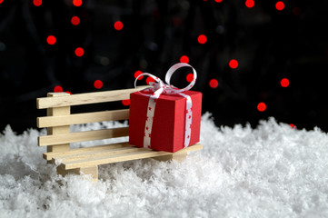 Box with a gift lying on the bench in the snow.