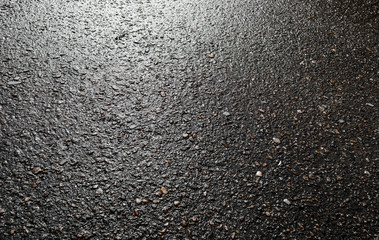 Wet asphalt road after the rain. Asphalt background. Asphalt perspective. Background and texture. Sun reflection