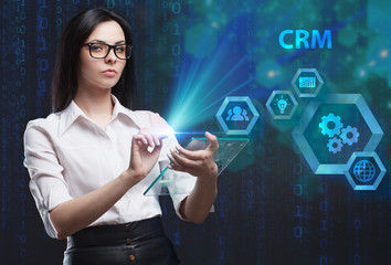 The concept of business, technology, the Internet and the network. A young entrepreneur working on a virtual screen of the future and sees the inscription: CRM