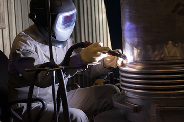 Welder with protective mask welding metal and sparks