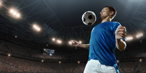 Soccer player performs an action play and beats the ball on a professional stadium. Player wears...