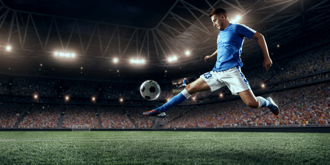 Soccer player performs an action play and beats the ball on a professional stadium. Player wears...