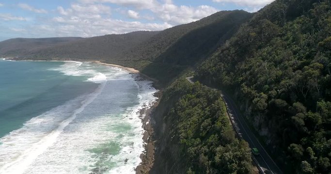 Steep rocks covered by gumtrees and scenic road on Great Ocean road in Victoria &ndash; coast of Southern ocean.
