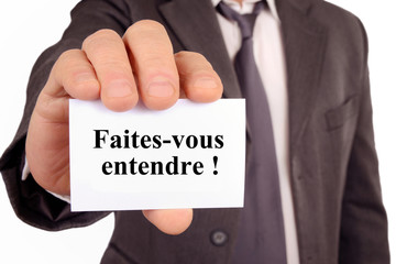 Homme tenant une carte sur laquelle est écrit faites-vous entendre 