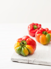 Sweet colorful raw peppers on a white table