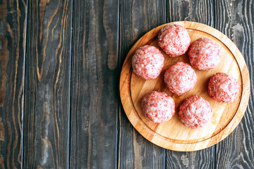 Raw cutlets on a wooden background