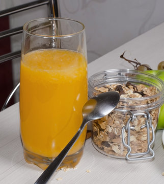 Orange juice, granola on a white table