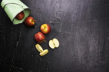 Apples from a bucket on a dark background