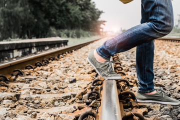 Woman wear jeans and sneaker shoes walk on the train railway,