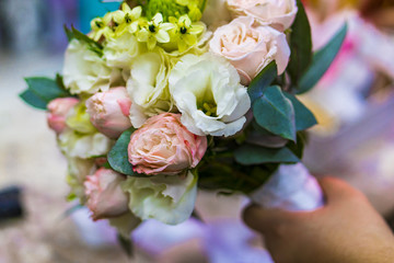 A multicolored bouquet in the hand.