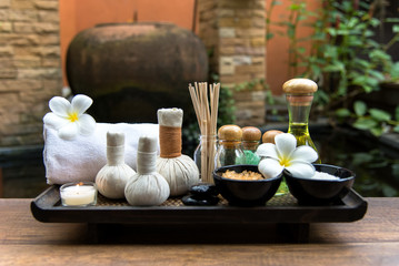 Thai spa composition treatments aroma therapy with candles and Plumeria flowers on wooden table...