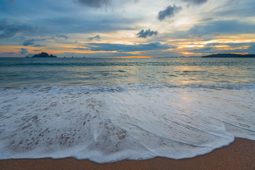 wave on the shore, clouds in the sky, sunset over the sea in Thailand