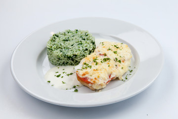 simple dish of Russian, Belarusian, Ukrainian cuisine on a white background chicken with cheese and rice and greens.