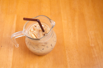 Iced coffee in the glass jar on the wood table 
