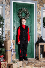 Obraz premium A boy stands in front of the door of the house