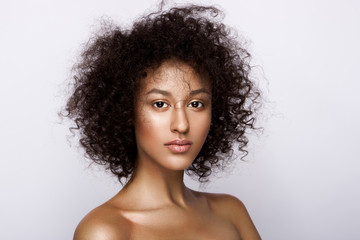 Fashion studio portrait of beautiful african american woman with perfect smooth glowing skin, nude make up